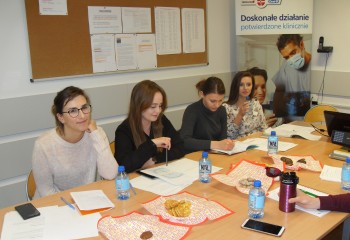 Zdjęcie przedstawia uczennice kierunku higienistka stomatologiczna realizujące kurs z zakresu periodontologii. Uczennice znajdują się w szkolnej pracowni Gabinet stomatologiczny.