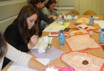 Zdjęcie przedstawia uczennice kierunku higienistka stomatologiczna realizujące kurs z zakresu periodontologii. Uczennice znajdują się w szkolnej pracowni Gabinet stomatologiczny.