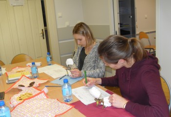 Zdjęcie przedstawia uczennice kierunku higienistka stomatologiczna realizujące kurs z zakresu periodontologii. Uczennice znajdują się w szkolnej pracowni Gabinet stomatologiczny.