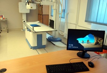 Komputer, a w tle znajduje się specjalistyczna maszyna